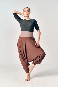 Kobieta w czekoladowych haremkach damskich od Hultaj Polski w pozie jogi