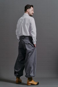 Mężczyzna w szarych luźnych spodniach Cwaniaki z kolekcji BRZYTWA z wysokim stanem