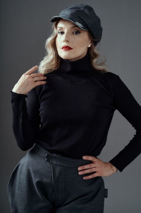 Kobieta w czarnym golfie Kosmopolitka Hultaj Polski z wełnianymi spodniami bryczesy – minimalistyczny look z wysokim kołnierzem
