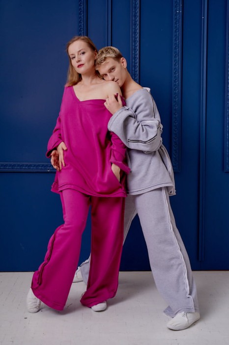 Damskie spodnie Sztosy Fuksja oversize w streetwearowym zestawie z bluzą Sigma na tle niebieskiej ściany.