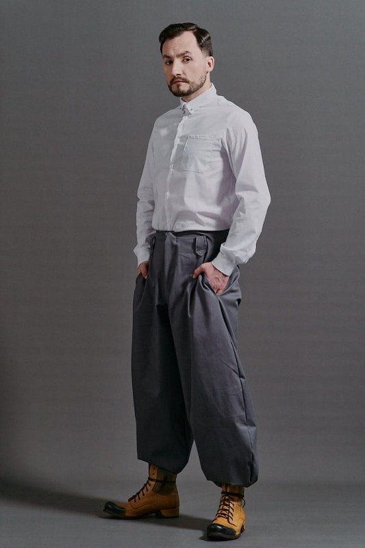 Szare szerokie spodnie męskie Cwaniaki z kolekcji BRZYTWA w streetwearowym stylu na neutralnym tle