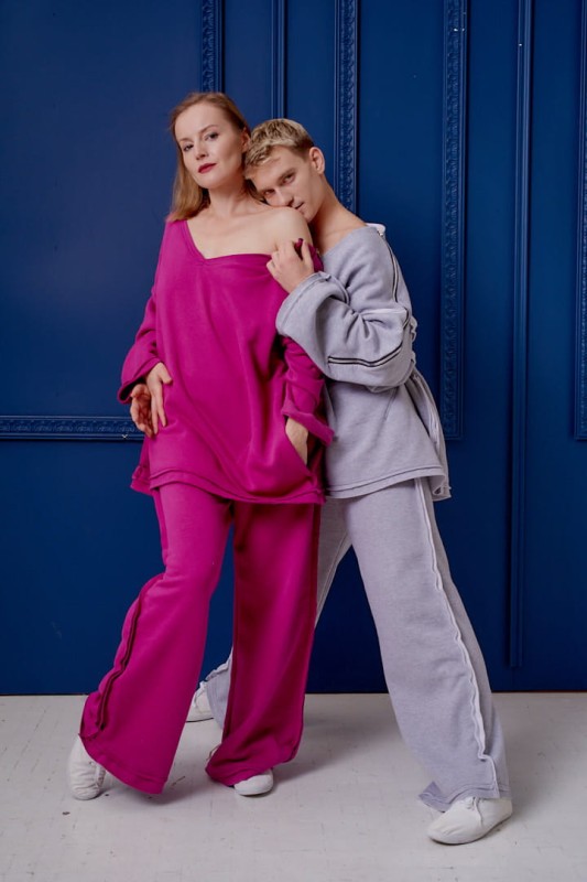 Damskie spodnie Sztosy Fuksja oversize w streetwearowym zestawie z bluzą Sigma na tle niebieskiej ściany.