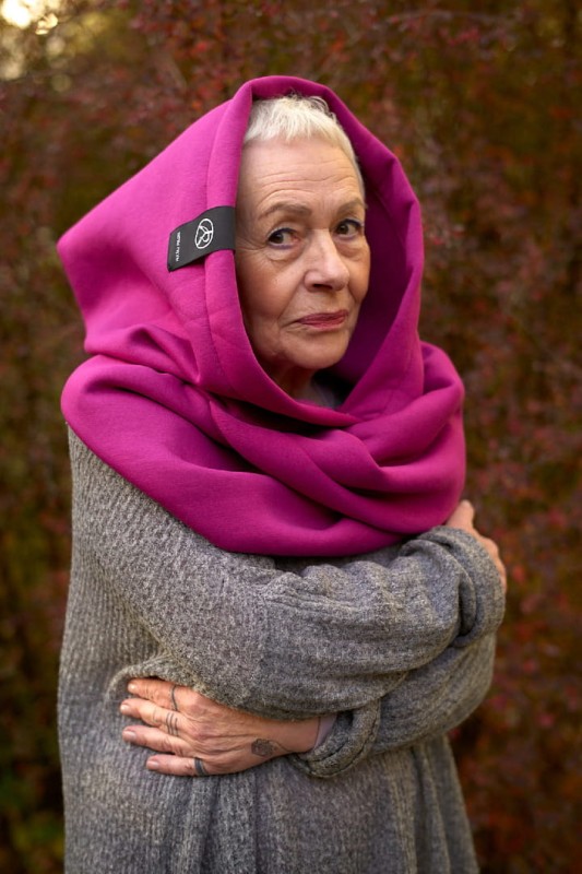 Kobieta w dzianinowym kapturze Fuksja Damskim w malinowym odcieniu na jasnym tle