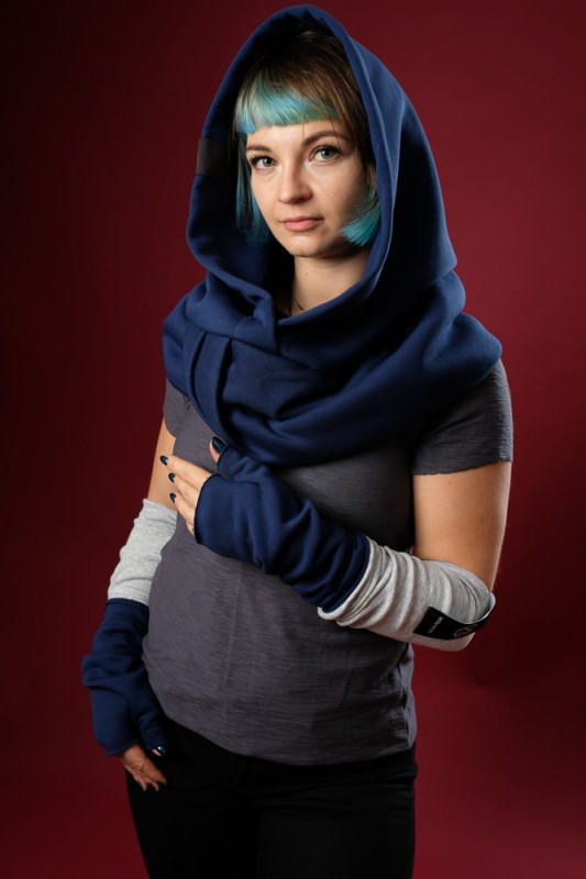 Kobieta w dzianinowym kapturze Granatowym Damskim w nocnym błękitnym odcieniu na czerwonym tle