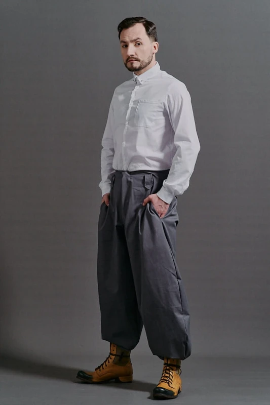 Szare szerokie spodnie męskie Cwaniaki z kolekcji BRZYTWA w streetwearowym stylu na neutralnym tle