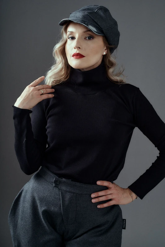 Kobieta w czarnym golfie Kosmopolitka Hultaj Polski z wełnianymi spodniami bryczesy – minimalistyczny look z wysokim kołnierzem