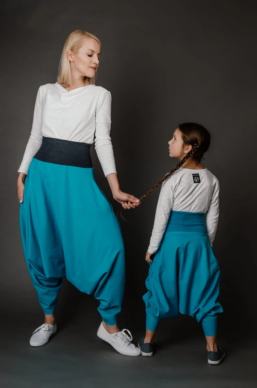 Komplet turkusowych spodni alladynki dla mamy i córki od Hultaj Polski w stylizacji z białymi longsleeve’ami